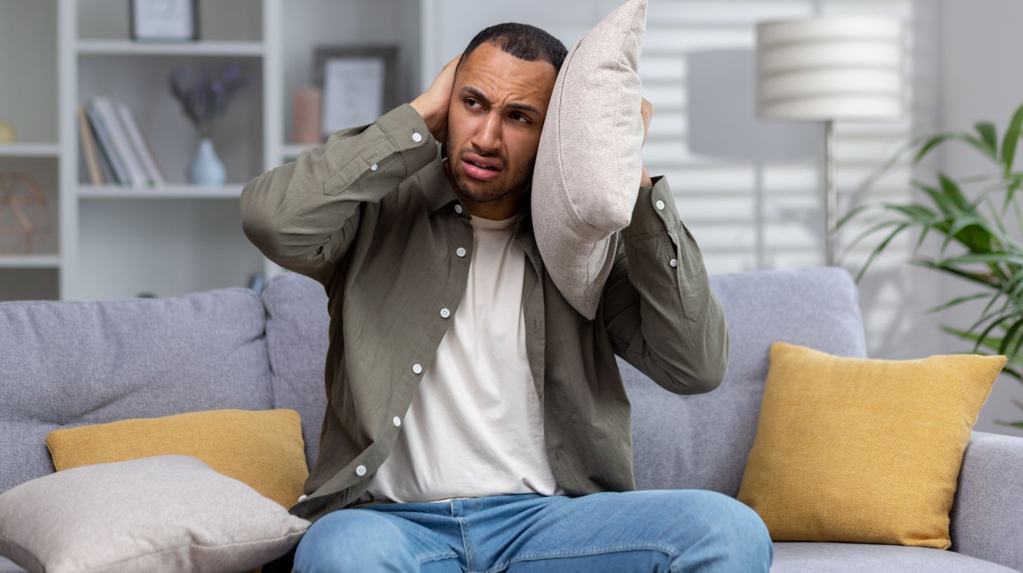 a man covering his ears to block out noise