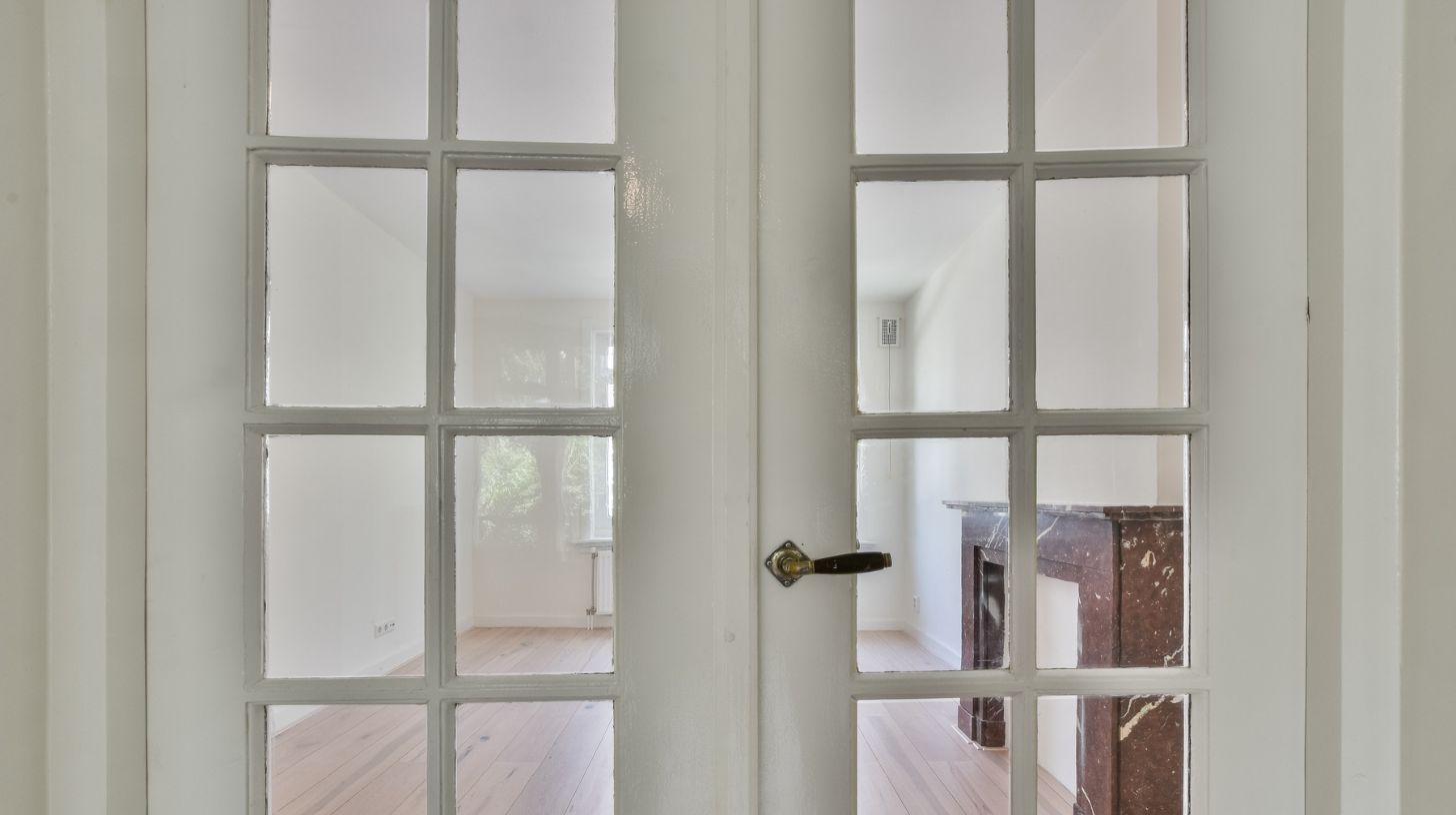 A close up of white french doors