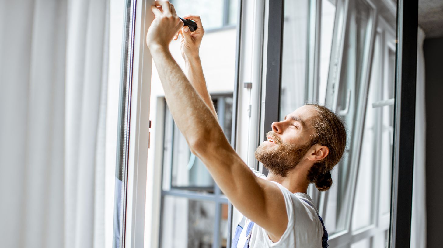 a workman adjusting window frames