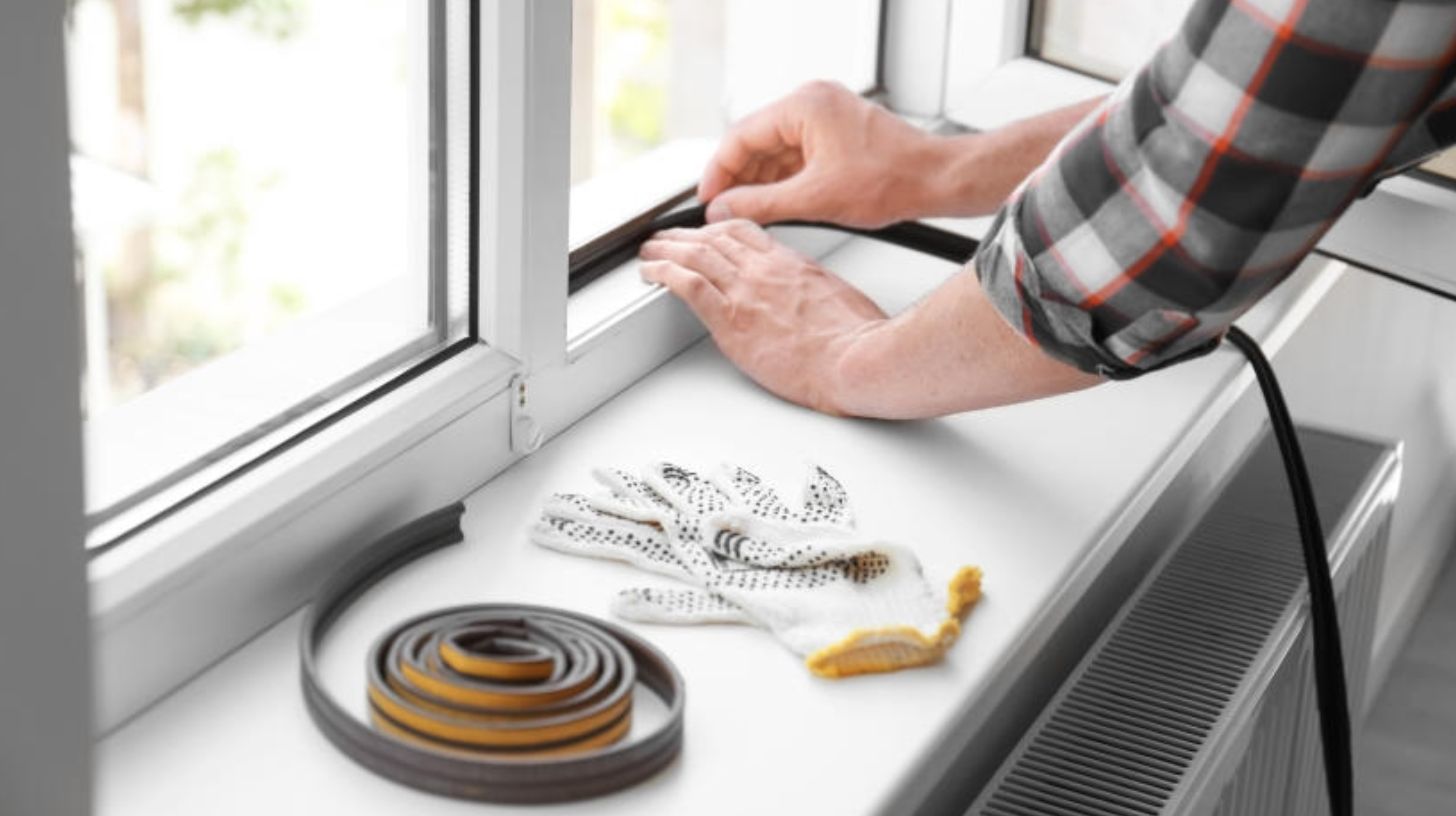 weather stripping being installed on a window weather stripping being installed on a window