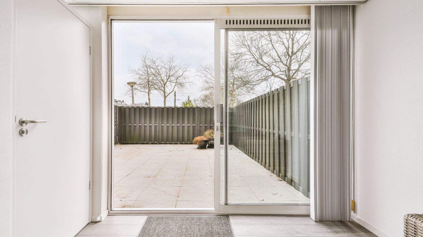 a white sliding door leading to a garden